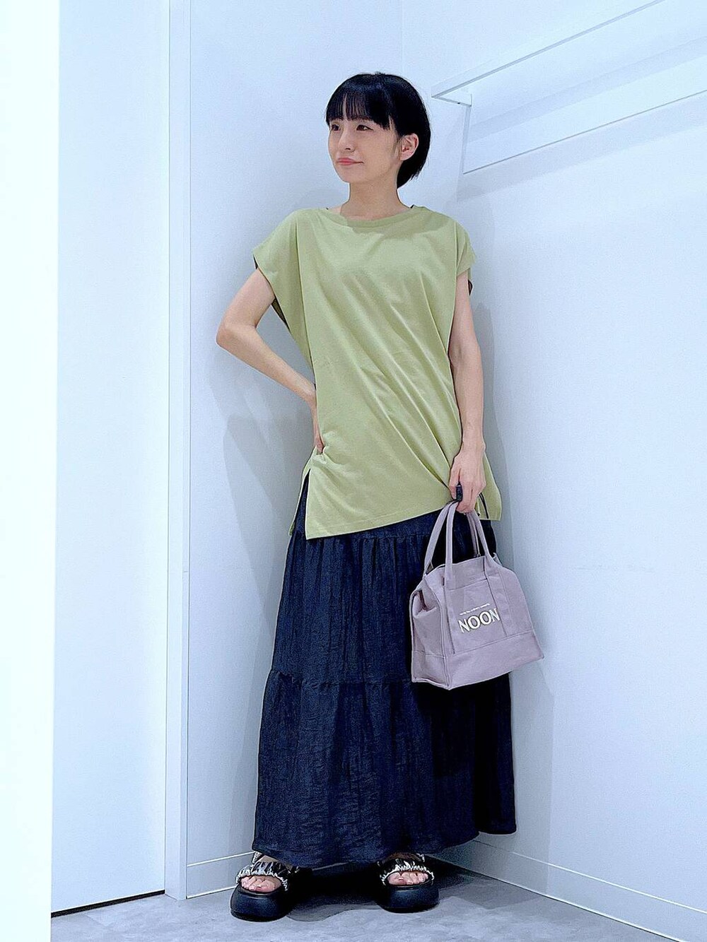 シルバー系のサンダル、グリーン系のTシャツ/カットソー、ブラック系のスカートを着用したレディースの夏コーディネートの2枚目の写真