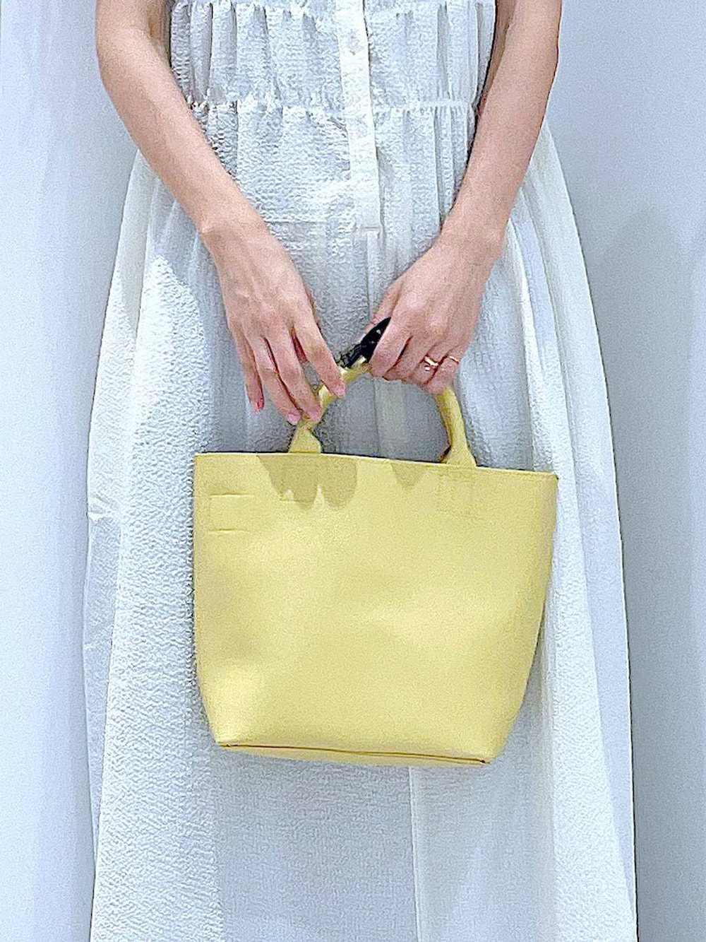 ブラック系のサンダル、ブルー系のデニムパンツ、ベージュ系のワンピースを着用したレディースの夏コーディネートの9枚目の写真