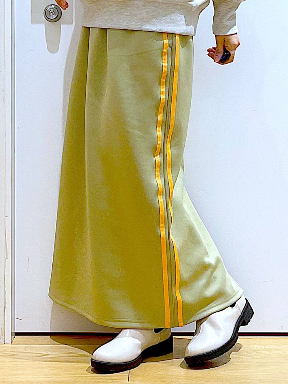 ベージュ系のスウェット、ベージュ系のブーツ、ホワイト系のトートバッグを着用したレディースの冬コーディネートの8枚目の写真