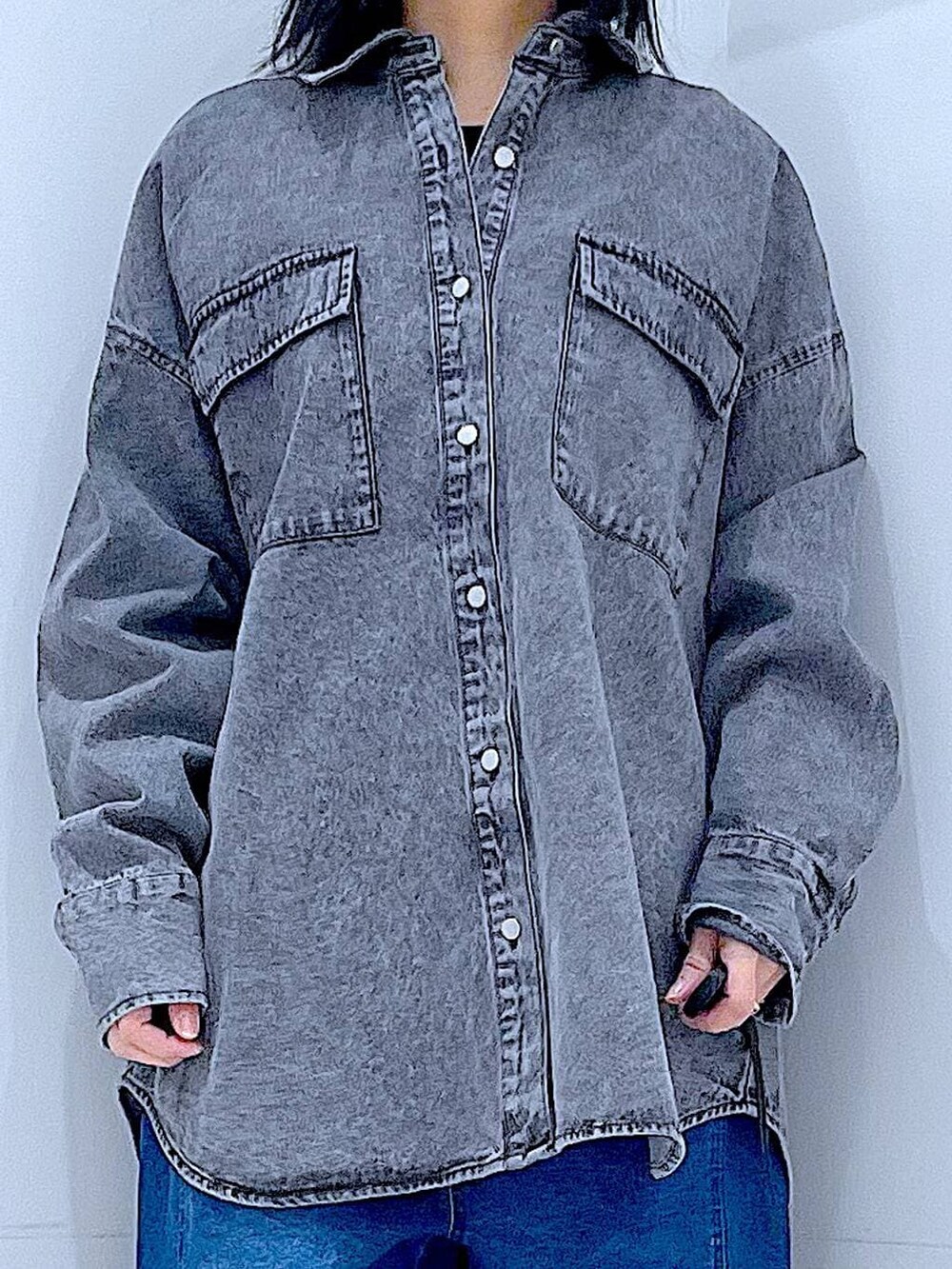 ブラウン系のボストンバッグ、ブルー系のデニムパンツ、ブラック系のシャツ/ブラウスを着用したレディースの冬コーディネートの7枚目の写真