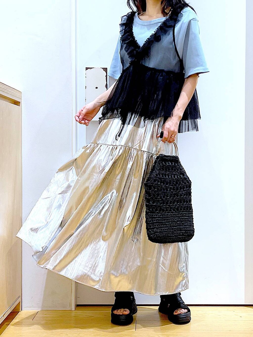 ブラック系のサンダル、ブルー系のTシャツ/カットソー、ブラック系のベストを着用したレディースの夏コーディネートの6枚目の写真