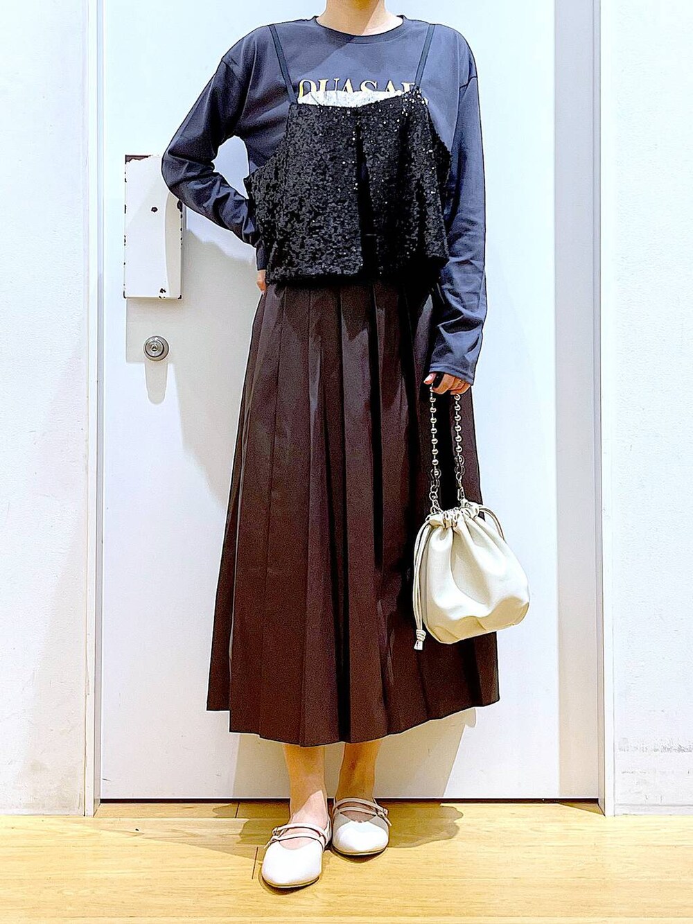 ベージュ系のショルダーバッグ、ホワイト系のパンプス、ブラック系のベストを着用したレディースの秋コーディネートの6枚目の写真