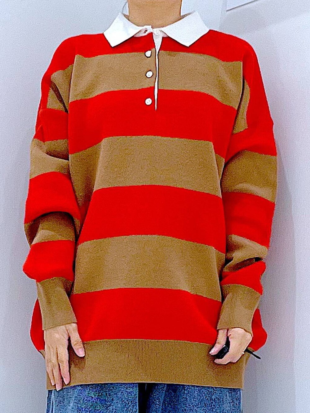 ブラック系のトートバッグ、レッド系のニット/セーター、ブルー系のデニムパンツを着用したレディースの冬コーディネートの7枚目の写真