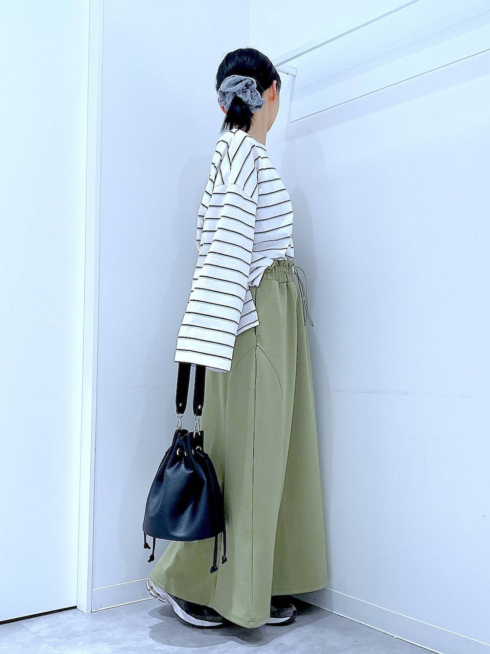 ブラック系のショルダーバッグ、グリーン系のスカート、ホワイト系のTシャツ/カットソーを着用したレディースの冬コーディネートの4枚目の写真