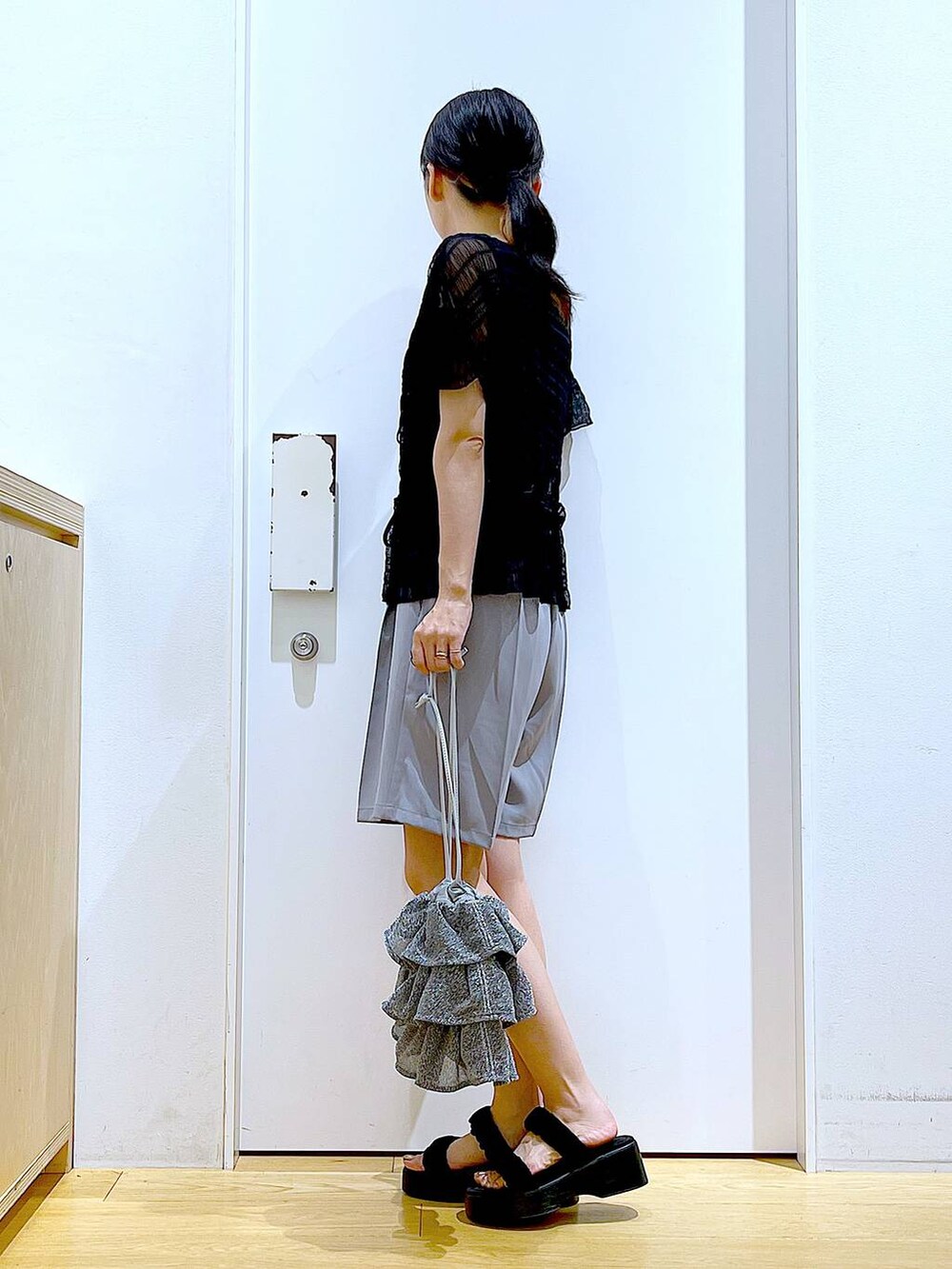 シルバー系のショルダーバッグ、グレー系のその他パンツ、ブラック系のサンダルを着用したレディースの夏コーディネートの3枚目の写真