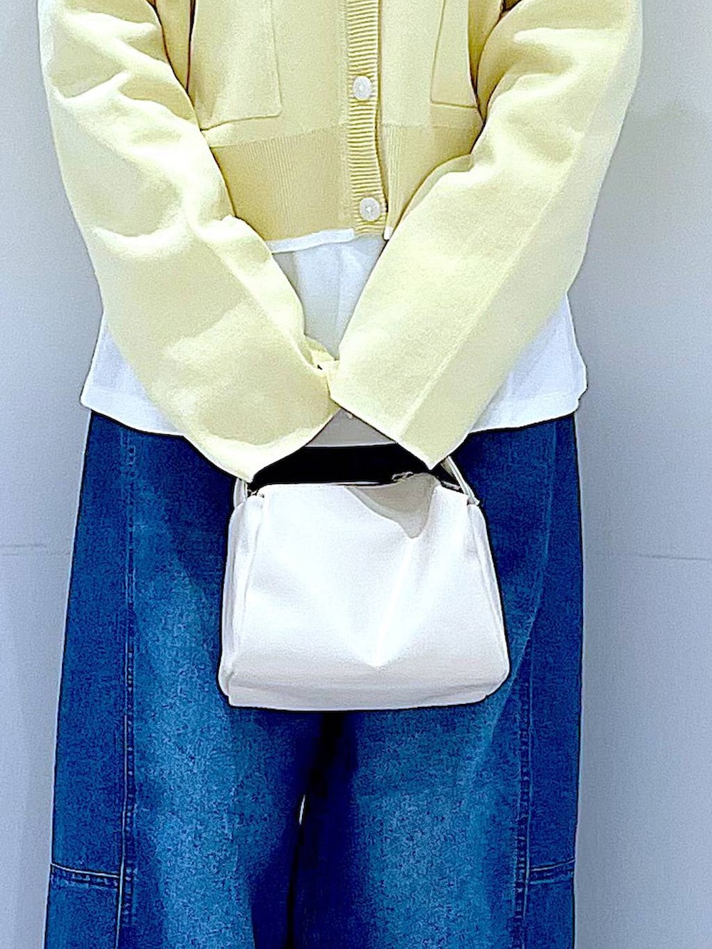 ホワイト系のショルダーバッグ、ホワイト系のTシャツ/カットソー、ブルー系のデニムパンツを着用したレディースの春コーディネートの9枚目の写真