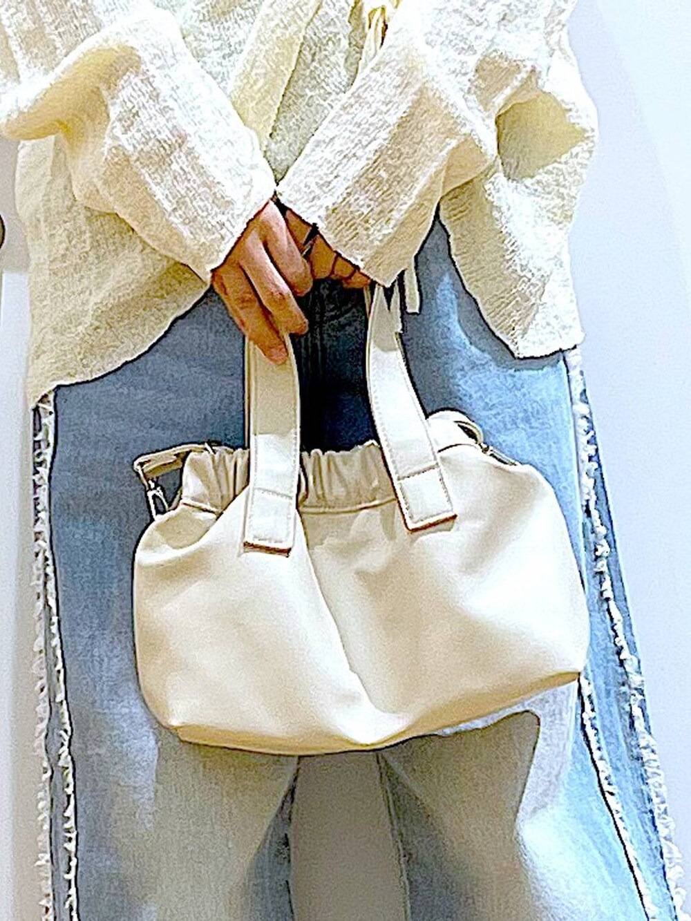 ホワイト系のショルダーバッグ、ホワイト系のパンプス、ブルー系のデニムパンツを着用したレディースの春コーディネートの9枚目の写真