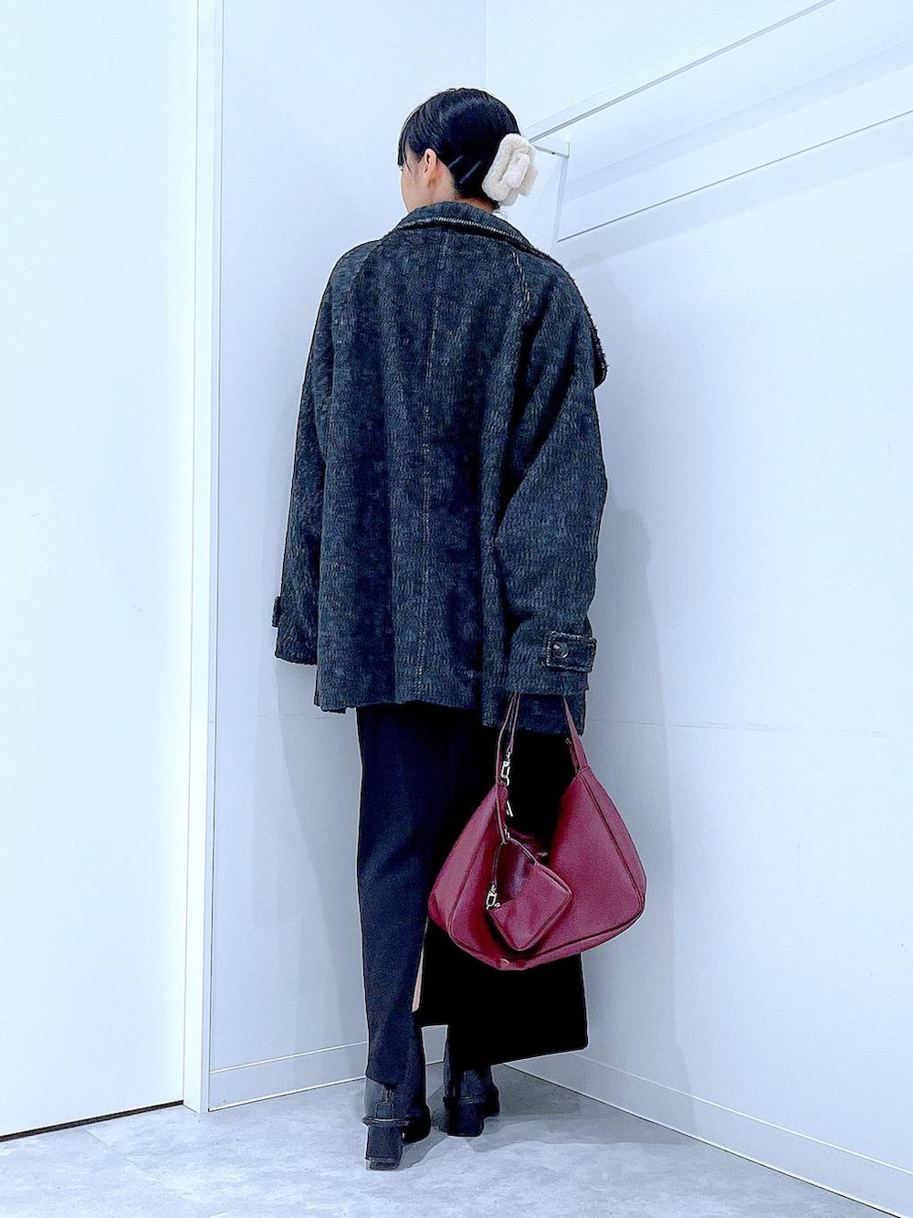 ブラック系のスカート、ブラック系のステンカラーコート、ブラック系のブーツを着用したレディースの冬コーディネートの5枚目の写真