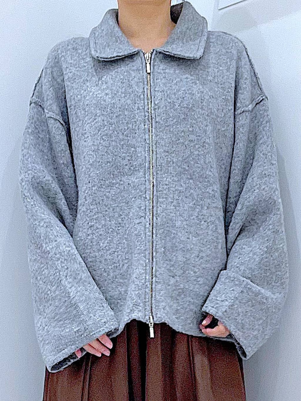 グレー系のブルゾン、ブラック系のブーツ、レッド系のショルダーバッグを着用したレディースの冬コーディネートの7枚目の写真