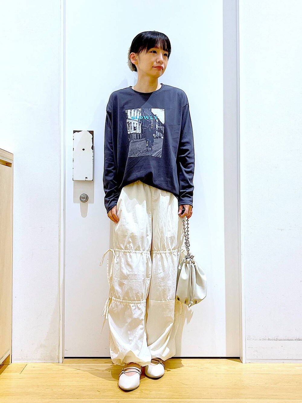 ベージュ系のショルダーバッグ、ホワイト系のパンプス、ホワイト系のその他パンツを着用したレディースの秋コーディネートの2枚目の写真