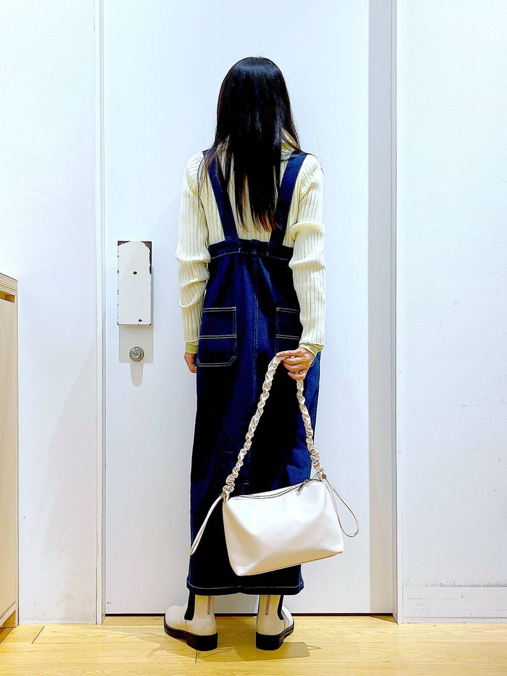 ブルー系のジャンパースカート、ベージュ系のカーディガン/ボレロ、グリーン系のその他トップスを着用したレディースの春コーディネートの5枚目の写真