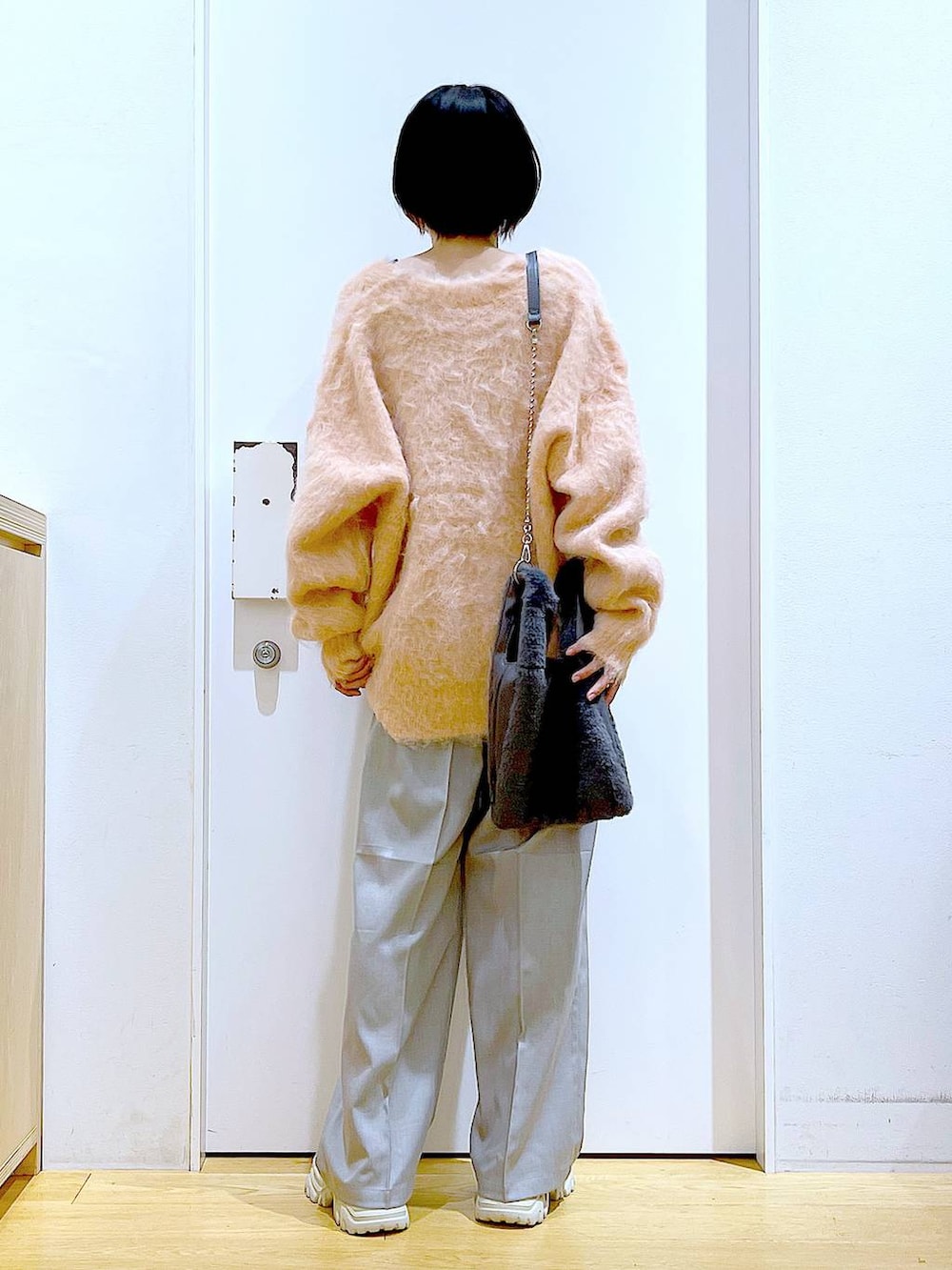 ピンク系のカーディガン/ボレロ、グレー系のショルダーバッグ、ベージュ系のブーツを着用したレディースの冬コーディネートの5枚目の写真