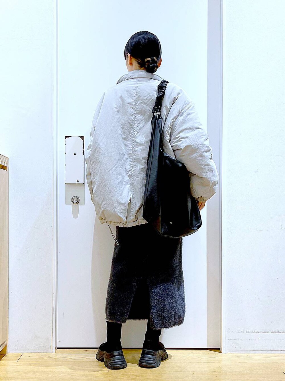 ブラック系のブーツ、ブルー系のスウェット、ブラック系のショルダーバッグを着用したレディースの冬コーディネートの5枚目の写真