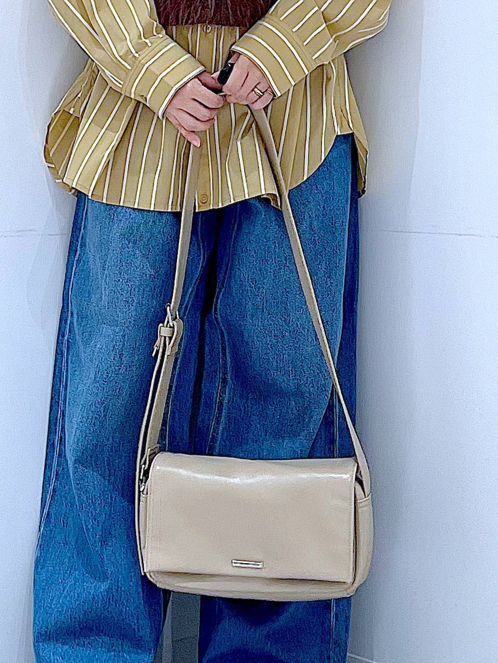 ブルー系のデニムパンツ、イエロー系のシャツ/ブラウス、ブラウン系のベストを着用したレディースの秋コーディネートの9枚目の写真