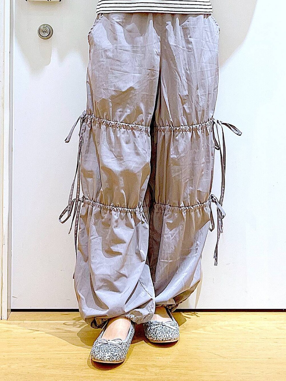 ホワイト系のハンドバッグ、シルバー系のパンプス、グレー系のその他パンツを着用したレディースの秋コーディネートの8枚目の写真