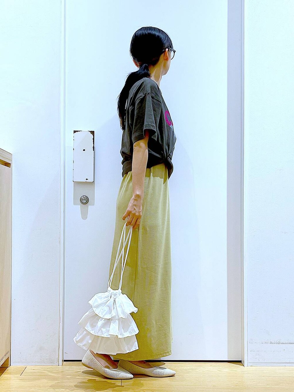 ホワイト系のショルダーバッグ、イエロー系のワンピース、ホワイト系のパンプスを着用したレディースの春コーディネートの4枚目の写真