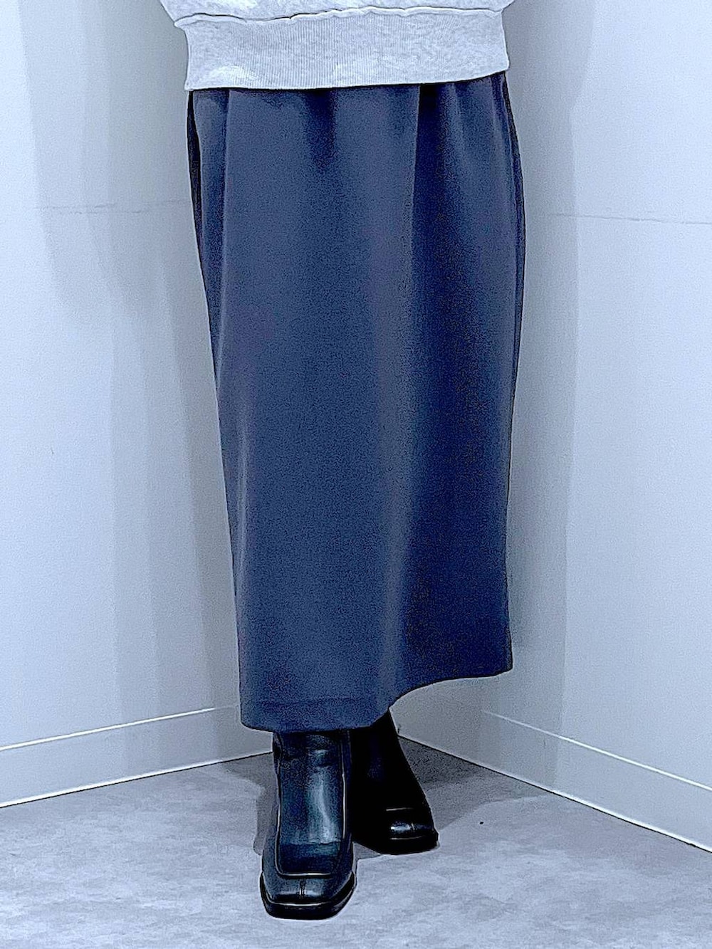 グレー系のスカート、グレー系のニット/セーター、ブラック系のブーツを着用したレディースの秋コーディネートの8枚目の写真