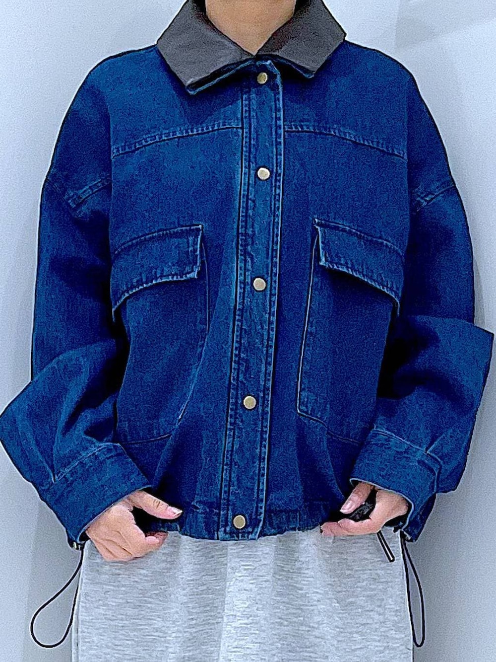 ブラック系のショルダーバッグ、グレー系のスカート、ブラック系のサンダルを着用したレディースの春コーディネートの7枚目の写真