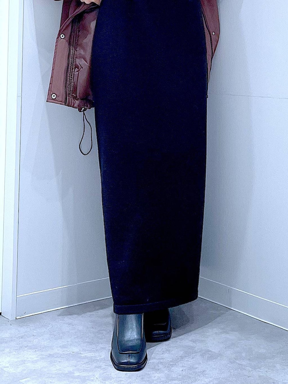 ブラウン系のブルゾン、ブラック系のブーツ、ブラック系のショルダーバッグを着用したレディースの冬コーディネートの8枚目の写真