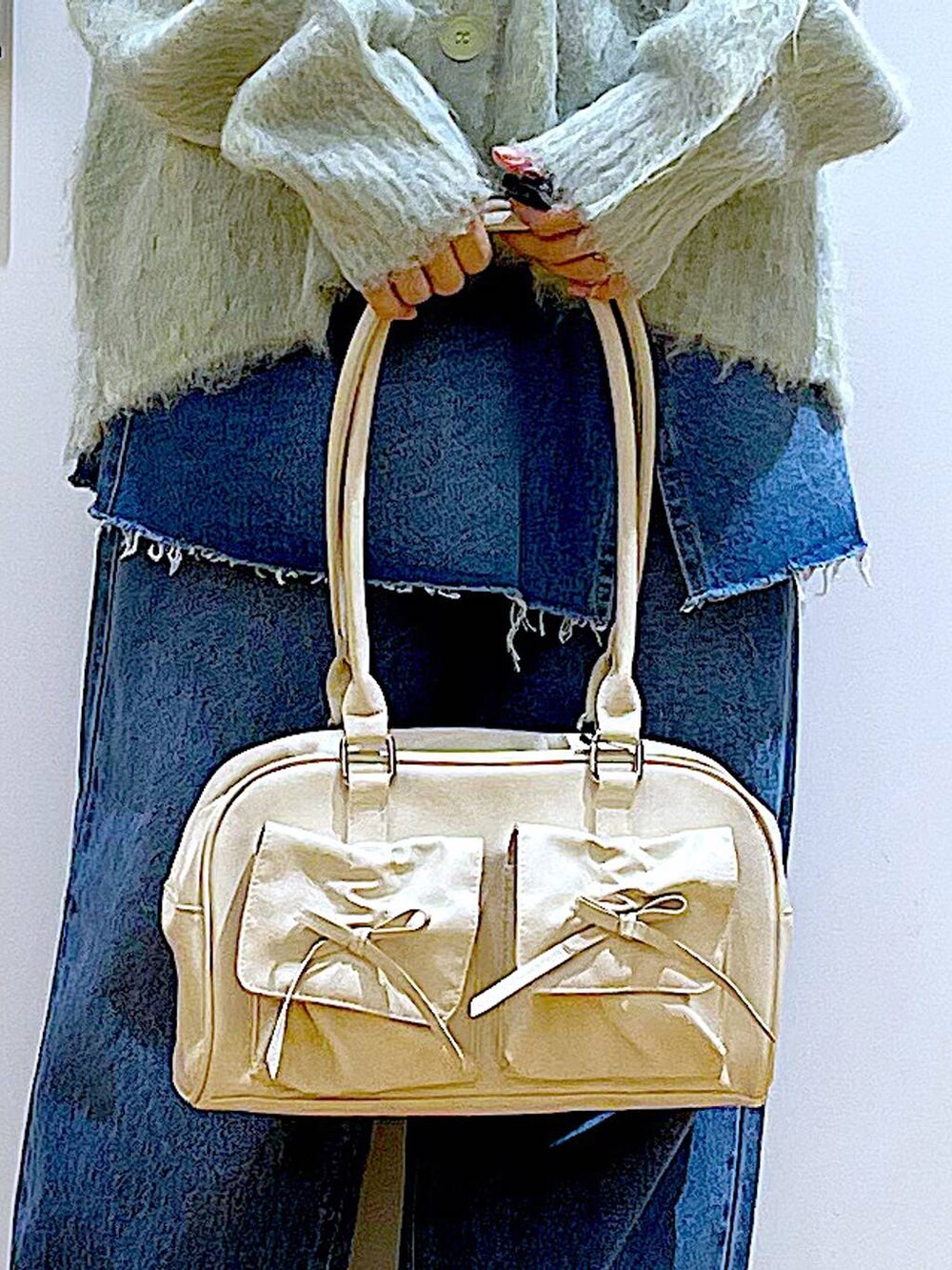 グリーン系のカーディガン/ボレロ、ブラック系のローファー、ブルー系のデニムパンツを着用したレディースの秋コーディネートの9枚目の写真