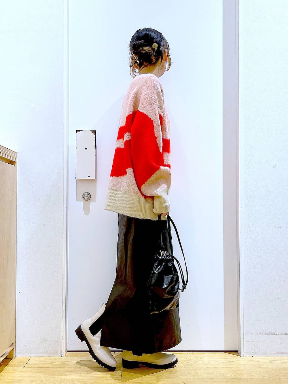 ベージュ系のブーツ、ブラック系のスカート、ブラック系のショルダーバッグを着用したレディースの冬コーディネートの4枚目の写真