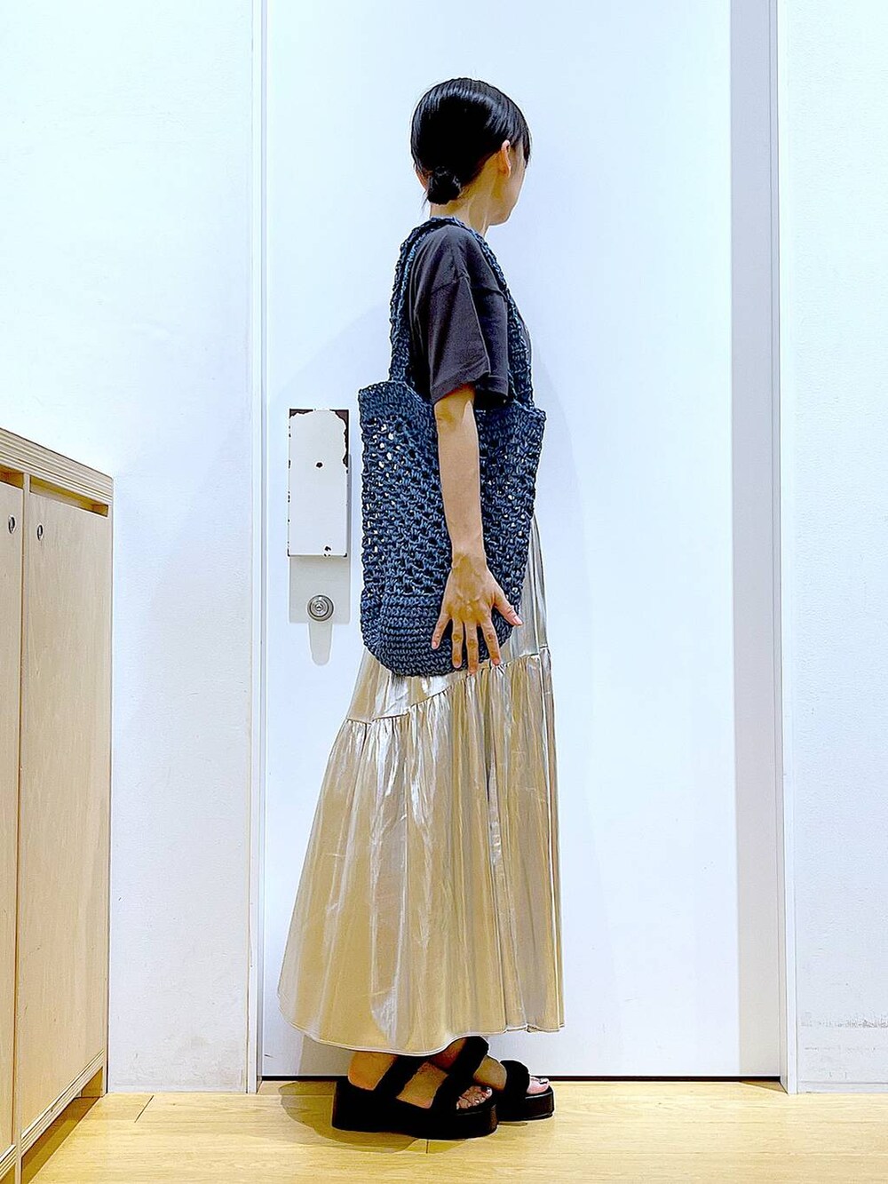 ブラック系のサンダル、シルバー系のスカート、ブルー系のトートバッグを着用したレディースの夏コーディネートの4枚目の写真