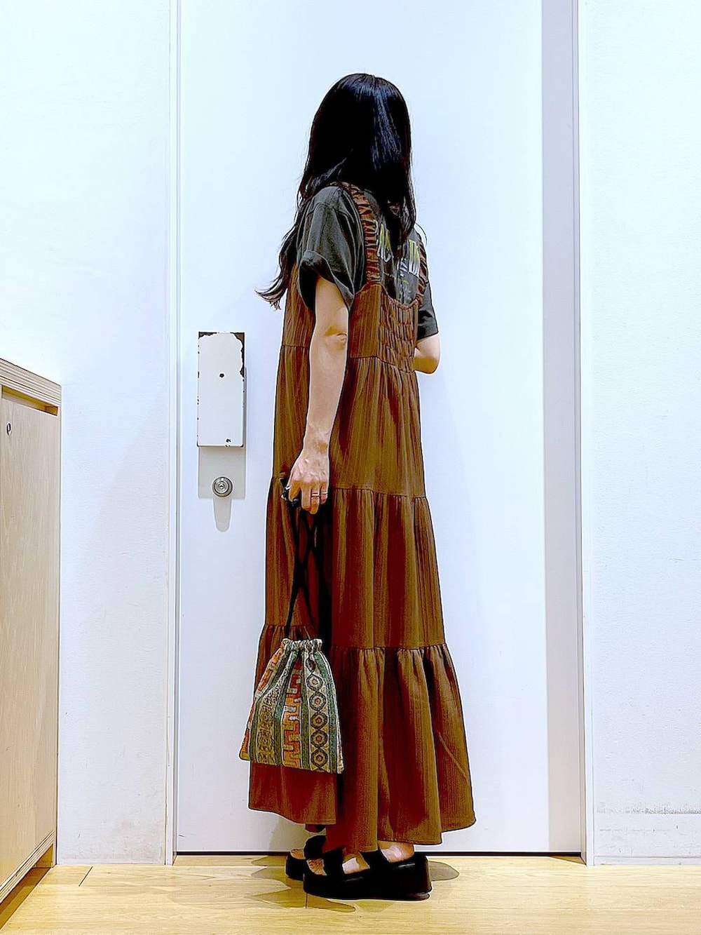 ブラウン系のショルダーバッグ、ブラック系のサンダル、グレー系のTシャツ/カットソーを着用したレディースの夏コーディネートの3枚目の写真