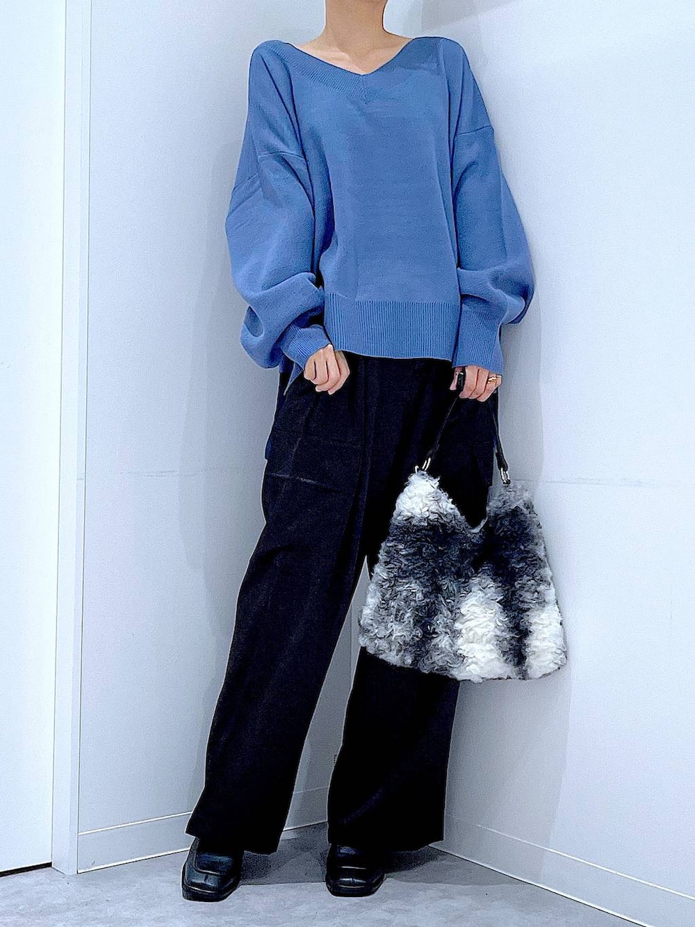 ブルー系のニット/セーター、ブラック系のブーツ、ブラック系のショルダーバッグを着用したレディースの冬コーディネートの6枚目の写真