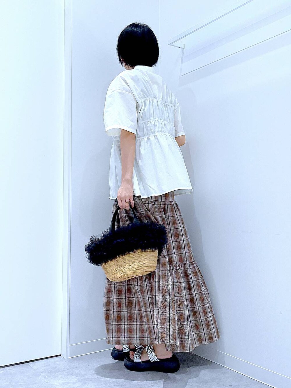 ベージュ系のショルダーバッグ、シルバー系のサンダル、ブラウン系のワンピースを着用したレディースの夏コーディネートの3枚目の写真