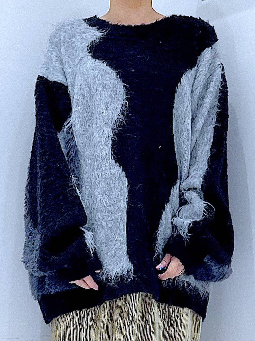 グレー系のニット/セーター、ブラック系のブーツ、ブラック系のショルダーバッグを着用したレディースの冬コーディネートの7枚目の写真