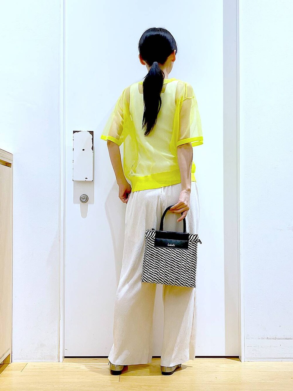 イエロー系のニット/セーター、ホワイト系のその他パンツ、ホワイト系のニット/セーターを着用したレディースの夏コーディネートの5枚目の写真