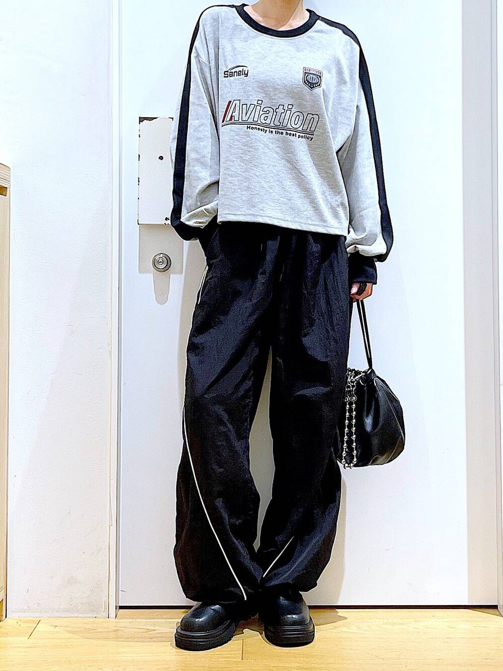 ブラック系のショルダーバッグ、ブラック系のブーツ、グレー系のTシャツ/カットソーを着用したレディースの秋コーディネートの6枚目の写真