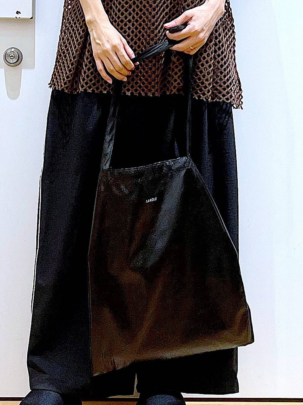 ブラック系のトートバッグ、ブラック系のニット/セーター、ブラック系のサンダルを着用したレディースの夏コーディネートの9枚目の写真