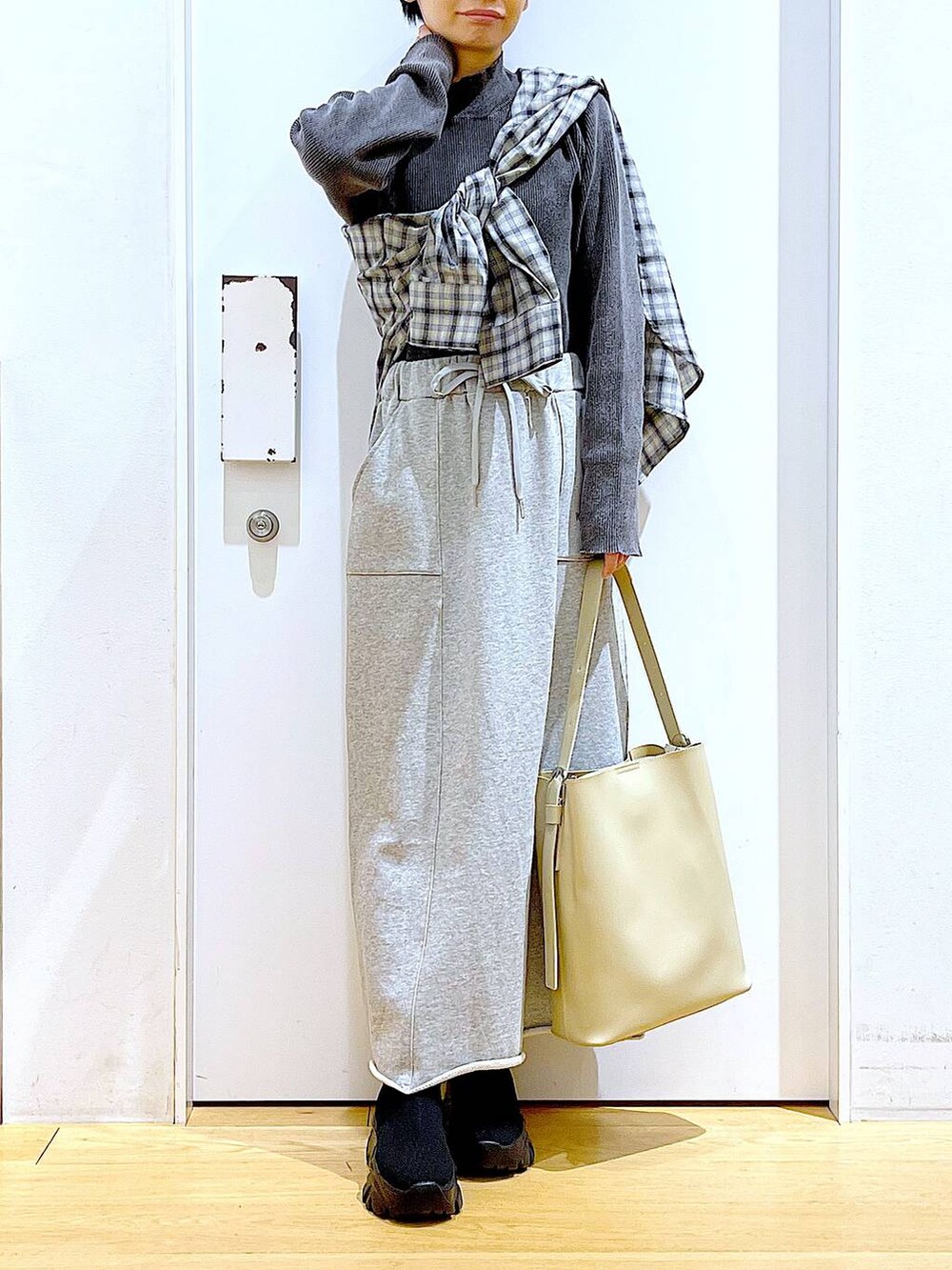 ブラック系のブーツ、ホワイト系のショルダーバッグ、ベージュ系のシャツ/ブラウスを着用したレディースの春コーディネートの6枚目の写真