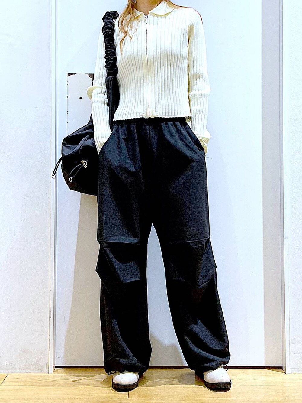 ブラック系のその他パンツ、ベージュ系のカーディガン/ボレロ、ベージュ系のブーツを着用したレディースの春コーディネートの6枚目の写真