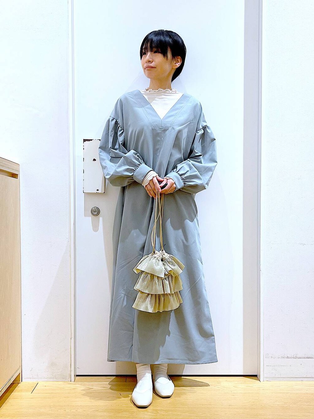 ベージュ系のTシャツ/カットソー、ホワイト系のパンプス、ベージュ系のショルダーバッグを着用したレディースの春コーディネートの2枚目の写真