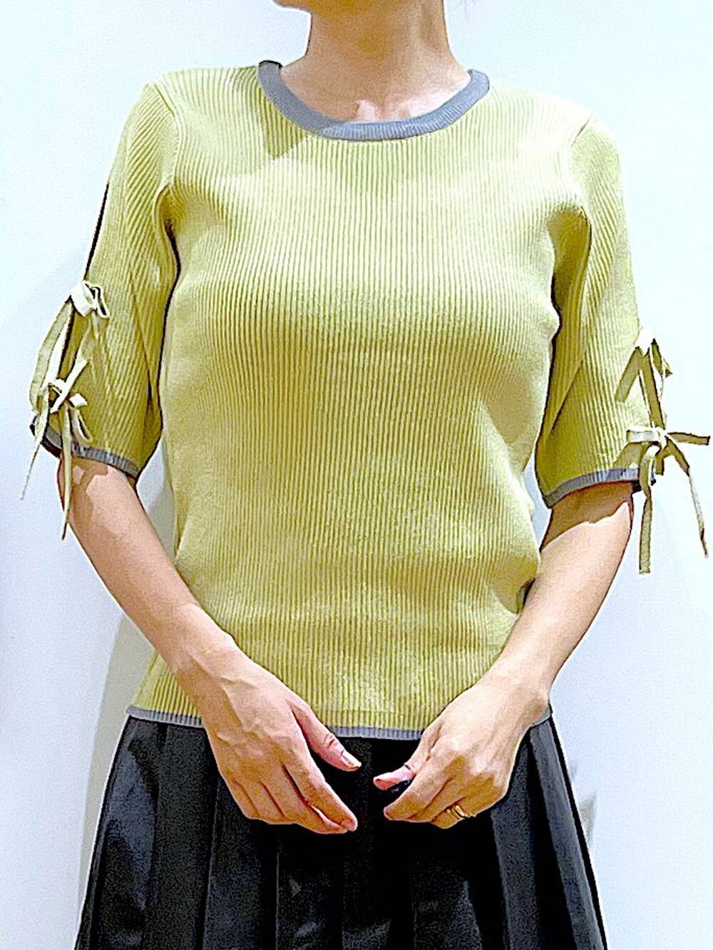 グレー系のショルダーバッグ、ブラック系のローファー、イエロー系のニット/セーターを着用したレディースの秋コーディネートの7枚目の写真