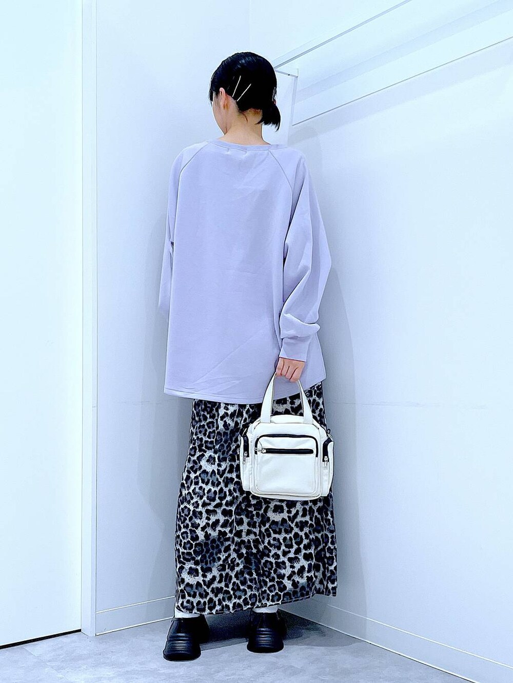 ホワイト系のショルダーバッグ、ブラック系のローファー、グレー系のスカートを着用したレディースの秋コーディネートの5枚目の写真