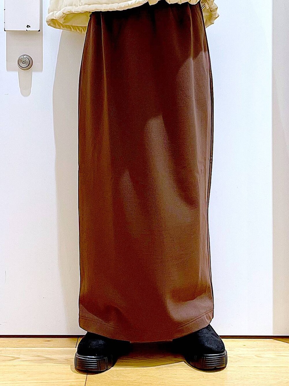 ベージュ系のショルダーバッグ、ブラック系のブーツ、ベージュ系のナイロンジャケットを着用したレディースの冬コーディネートの8枚目の写真