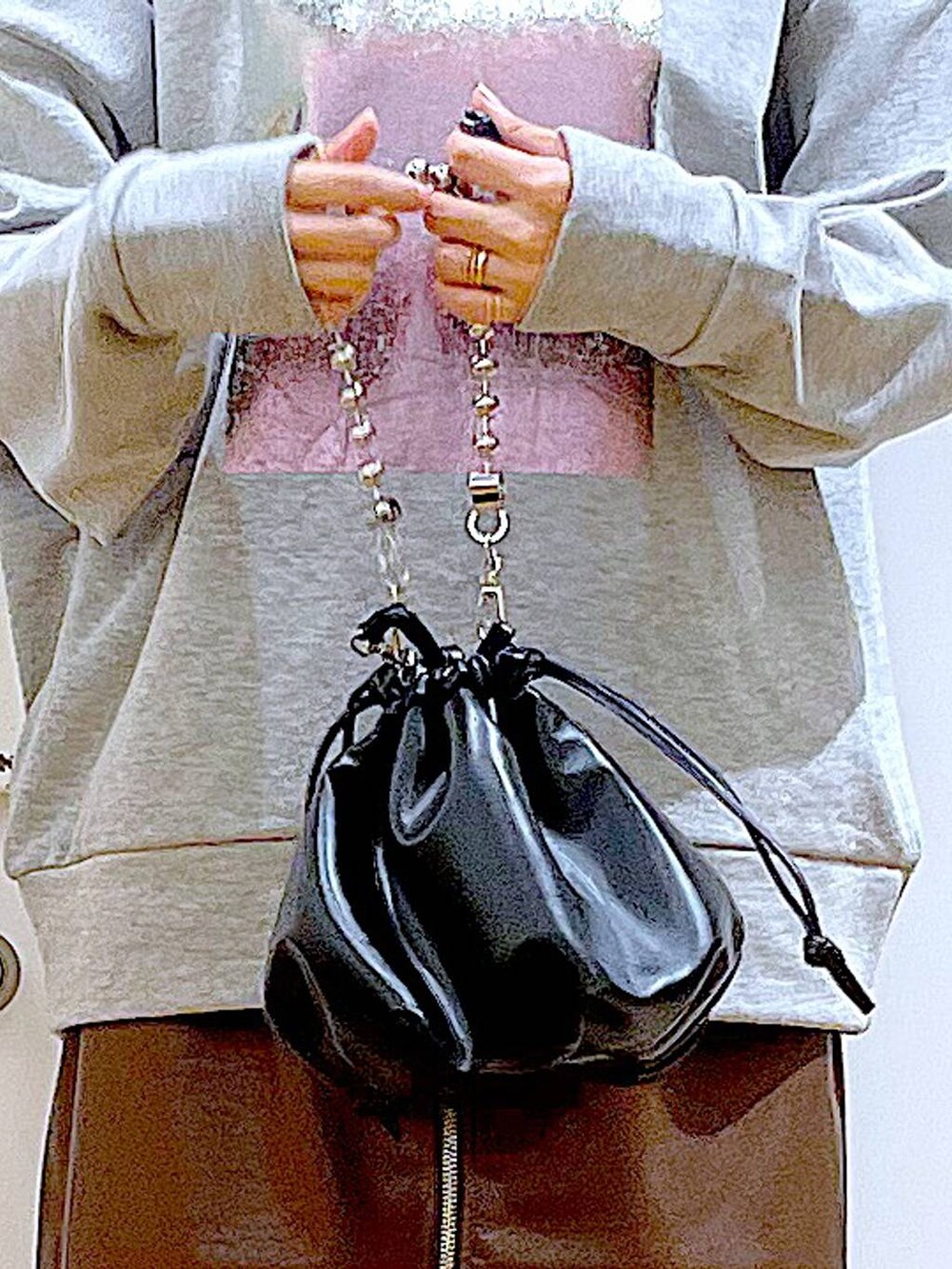 ブラウン系のスカート、ブラック系のショルダーバッグ、ブラック系のブーツを着用したレディースの冬コーディネートの9枚目の写真