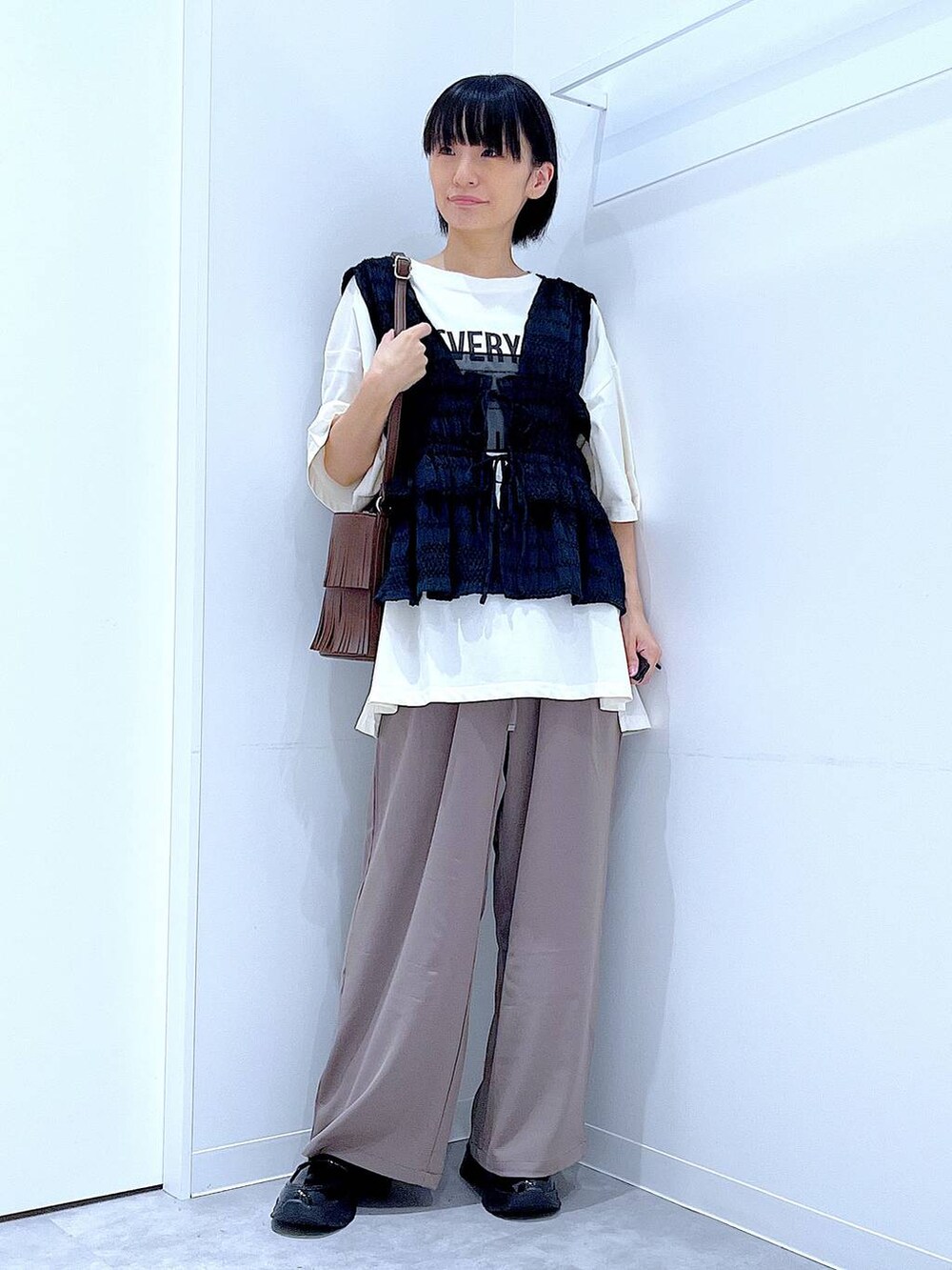 ブラック系のローファー、ブラウン系のショルダーバッグ、ブラウン系のその他パンツを着用したレディースの秋コーディネートの2枚目の写真