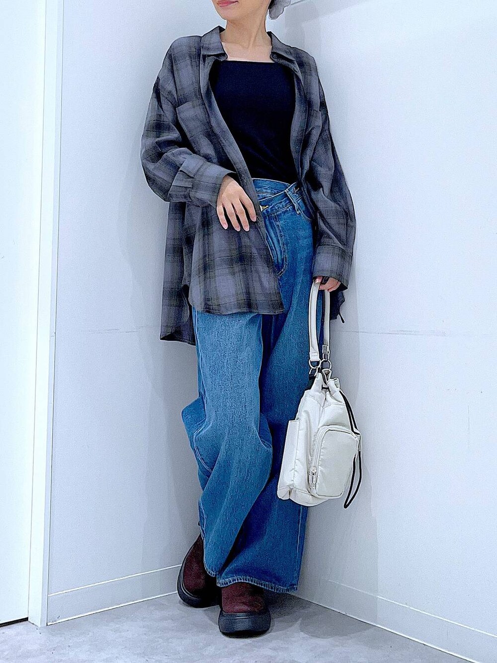 ブルー系のデニムパンツ、グレー系のシャツ/ブラウス、ホワイト系のハンドバッグを着用したレディースの秋コーディネートの6枚目の写真