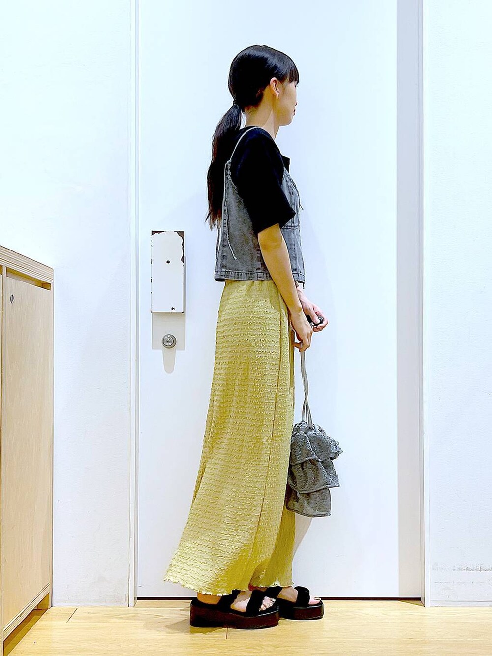 シルバー系のショルダーバッグ、グリーン系のスカート、ブラック系のTシャツ/カットソーを着用したレディースの夏コーディネートの4枚目の写真