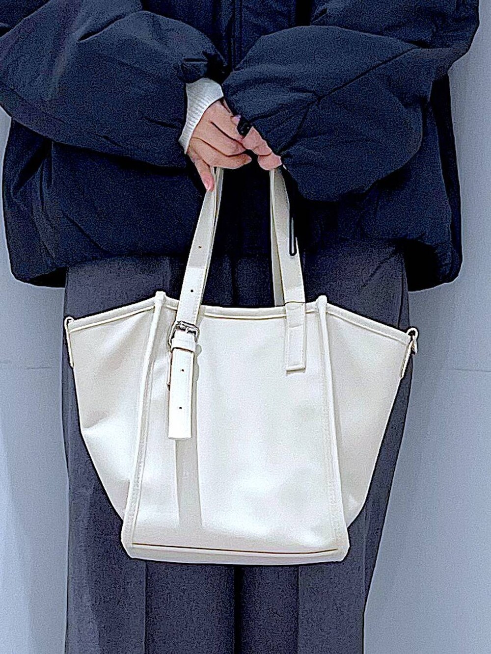 ブラック系のブルゾン、ブラック系のブーツ、グレー系のスラックスを着用したレディースの冬コーディネートの9枚目の写真