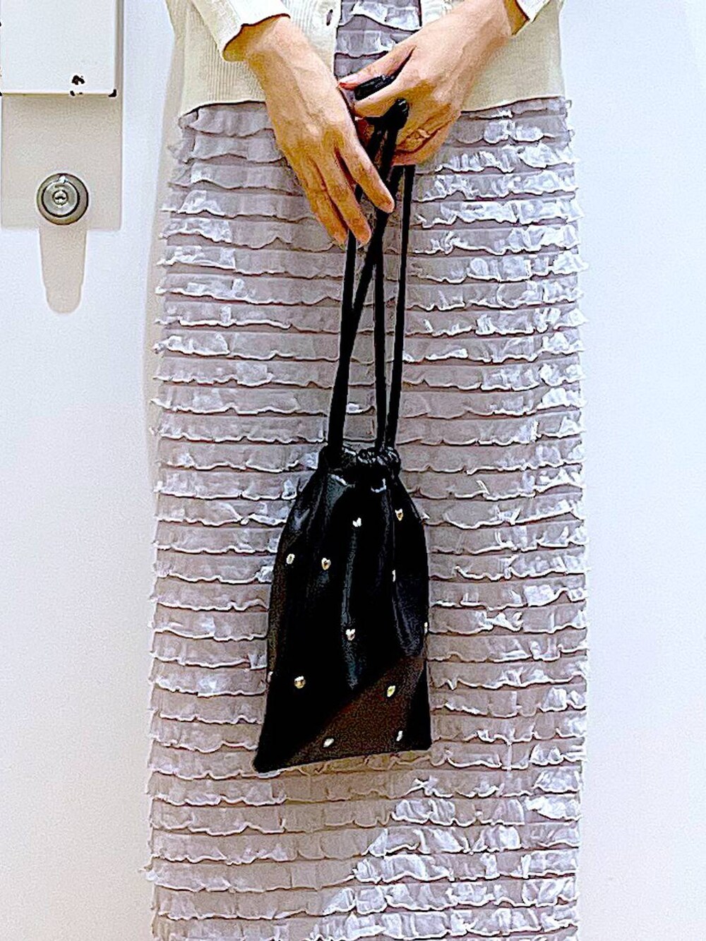 ブラック系のサンダル、ブラック系のショルダーバッグ、ホワイト系のカーディガン/ボレロを着用したレディースの夏コーディネートの9枚目の写真