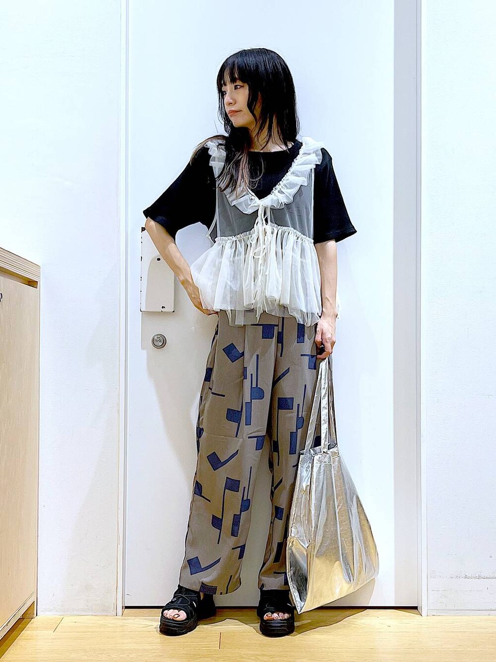 シルバー系のトートバッグ、グレー系のその他パンツ、ブラック系のサンダルを着用したレディースの夏コーディネートの2枚目の写真