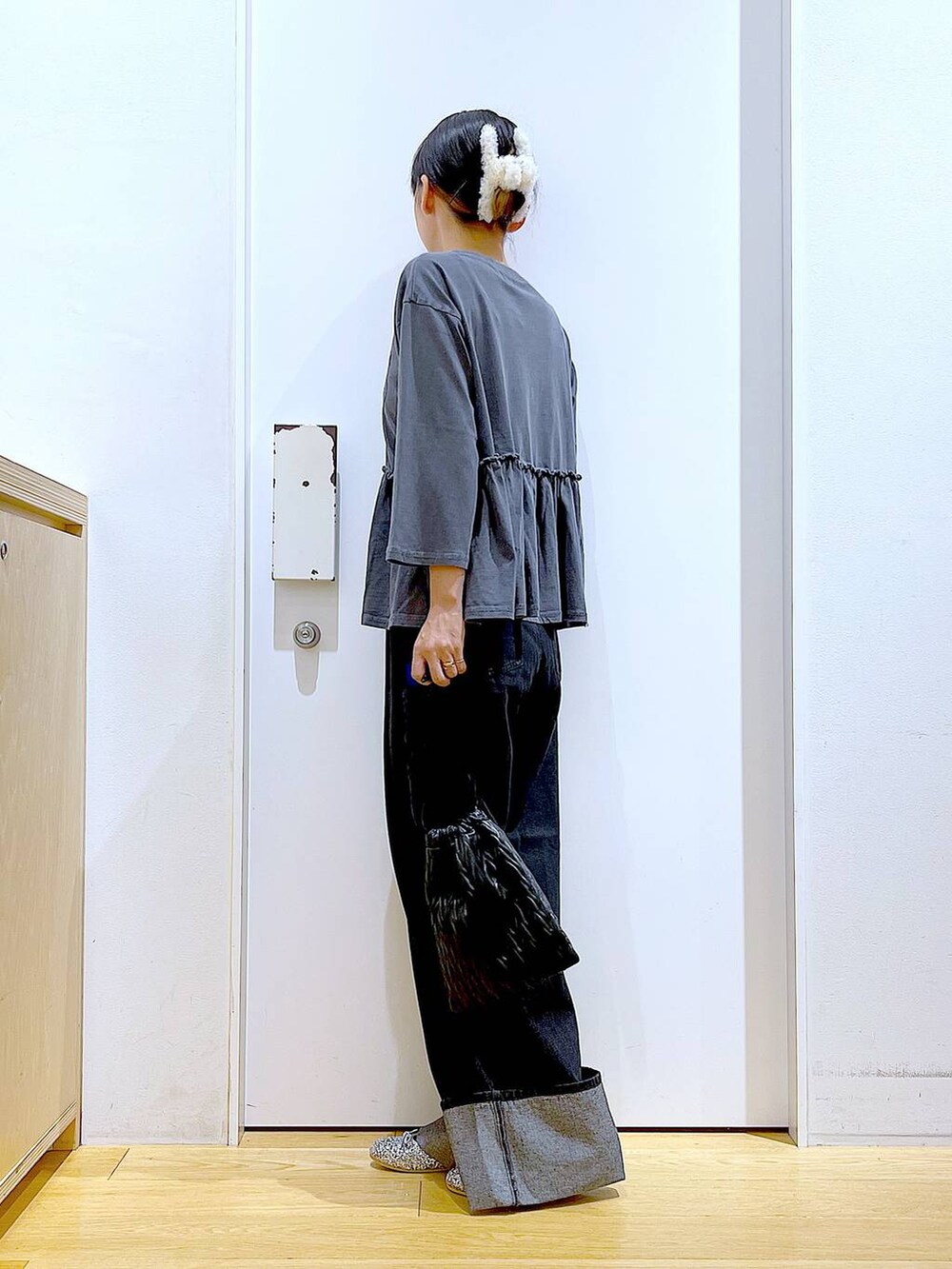 ブラック系のショルダーバッグ、シルバー系のパンプス、ブラック系のデニムパンツを着用したレディースの秋コーディネートの3枚目の写真