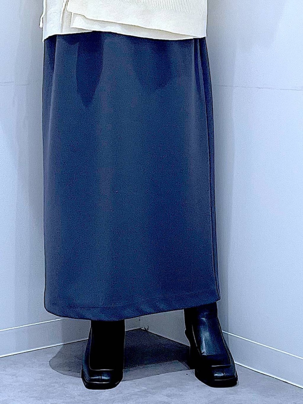 グレー系のスカート、ブラック系のショルダーバッグ、ブラック系のブーツを着用したレディースの冬コーディネートの8枚目の写真