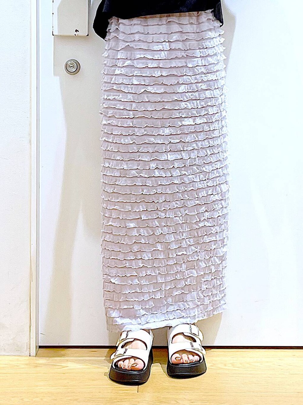 ホワイト系のサンダル、ブラック系のショルダーバッグ、シルバー系のベストを着用したレディースの夏コーディネートの8枚目の写真