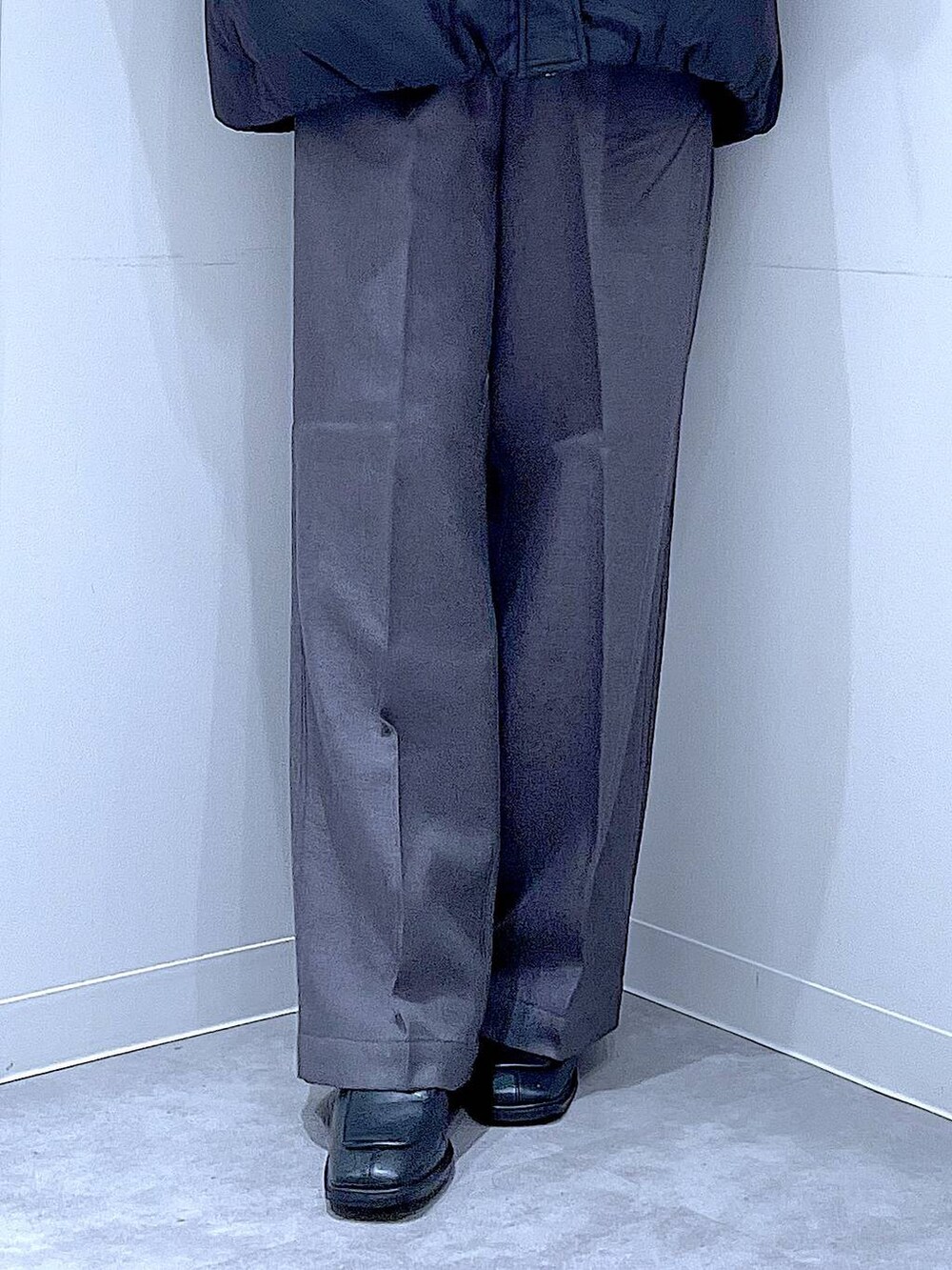 ブラック系のブルゾン、ブラック系のブーツ、グレー系のスラックスを着用したレディースの冬コーディネートの8枚目の写真